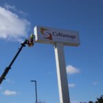 Sign technician performing maintenance for a credit union's signage.