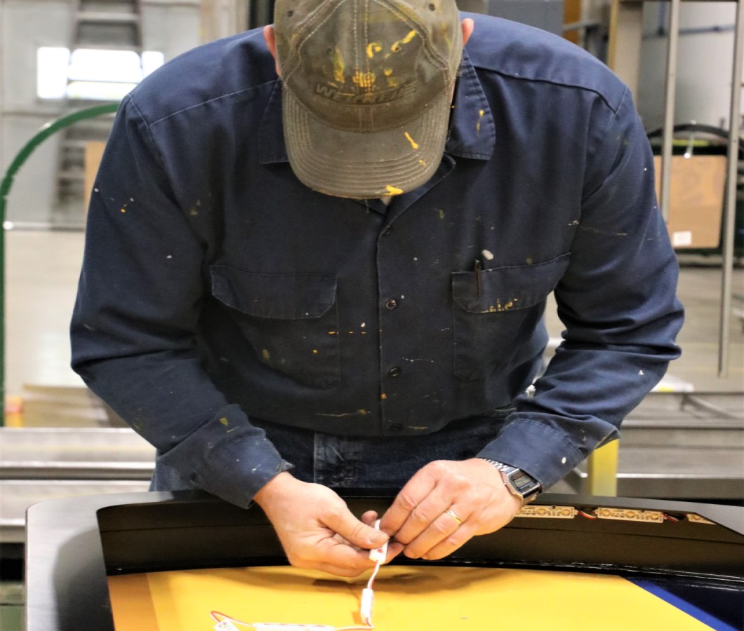 Sign technician wiring a custom sign.